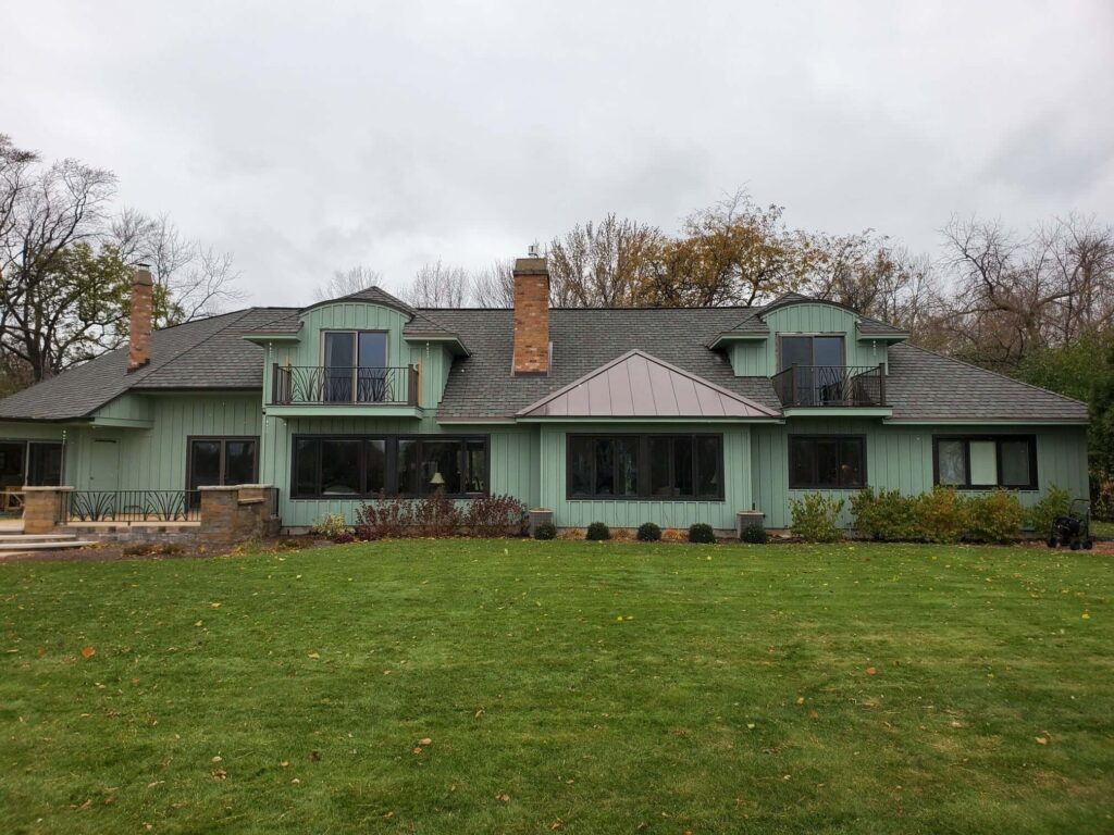 Green home with a balcony and grass around