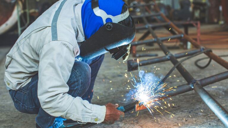 Metal Worker Welding a Guardrail